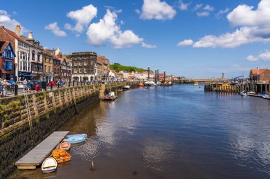 Whitby, Kuzey Yorkshire, İngiltere - 21 Haziran 2023 Esk Nehri üzerindeki Whitby Köprüsü 'nden iskeleye doğru görüş