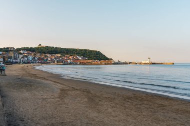 Scarborough, Kuzey Yorkshire, İngiltere - 22 Haziran 2023: Akşam ışığında Scarborough Deniz Feneri, South Bay Beach 'ten görüldü.
