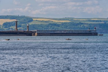 Whitby, Kuzey Yorkshire, İngiltere - 21 Haziran 2023: Doğu Kayalıkları 'ndaki Kuzey Denizi kıyısından deniz fenerlerine doğru görüş