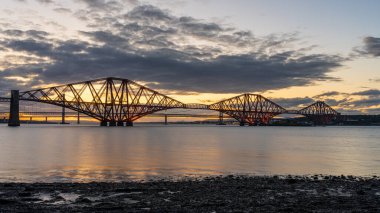 Güney Queensferry, Edinburgh, İskoçya, İngiltere 'den görülen Forth Bridge' de akşam atmosferi