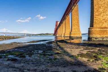 South Queensferry, City of Edinburgh, Scotland, UK - September 12, 2023: Bridges over the Firth of Forth, with the Queensferry Crossing and the Forth Road Bridge on the left and the Forth Bridge on the right clipart