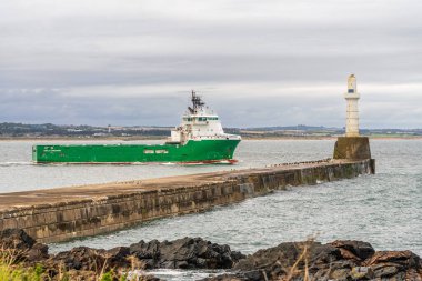 Aberdeen, İskoçya, İngiltere - 17 Eylül 2023: Limandan ayrılan ve Aberdeen Güney İskelesi Deniz fenerini geçen bir tekne