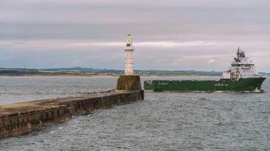Aberdeen, İskoçya, İngiltere - 17 Eylül 2023: Limandan ayrılan ve Aberdeen Güney İskelesi Deniz fenerini geçen bir tekne