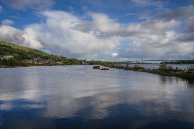 Clyde Nehri kıyısında Bowling, Batı Dunbartonshire, İskoçya 'da, Arkaplanda Erskine Köprüsü olan bir gemi enkazı