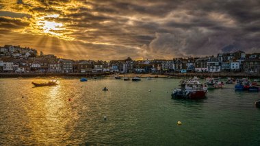 St. Ives, Cornwall, İngiltere - 30 Mayıs 2022: Limanda akşam güneşi ve bulutlar