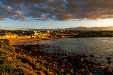 St Ives, Cornwall, England, UK - May 30, 2022: Golden hour and dramatic clouds on Porthmeor Beach clipart