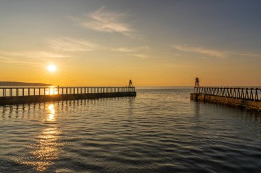 Batı 'da gün batımı ve Whitby' deki Doğu İskelesi, Kuzey Yorkshire, İngiltere, İngiltere
