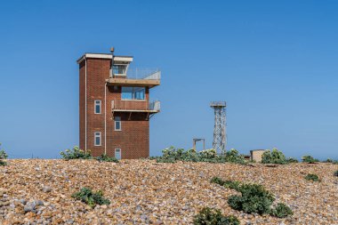 Dungeness, Kent, İngiltere 'de Eski Cankurtaran İstasyonu ve Yeni Deniz Feneri' nin olduğu plaj.