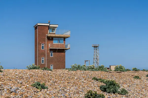 Dungeness, Kent, İngiltere 'de Eski Cankurtaran İstasyonu ve Yeni Deniz Feneri' nin olduğu plaj.
