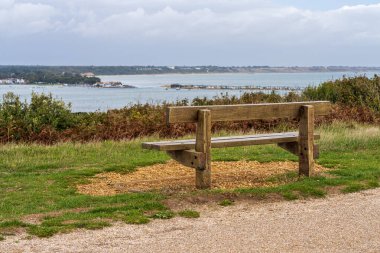 Mudeford Quay 'e ve Hengistbury Head, Dorset, İngiltere' deki Mudeford Kumsalındaki evlere bakan bir bank.