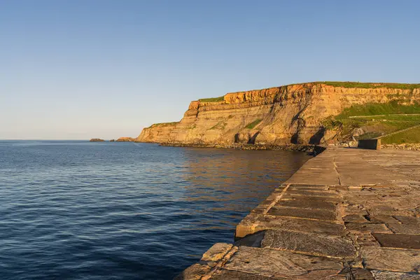 Akşam ışığı Whitby, North Yorkshire, İngiltere 'deki Doğu Kayalıkları üzerinde.