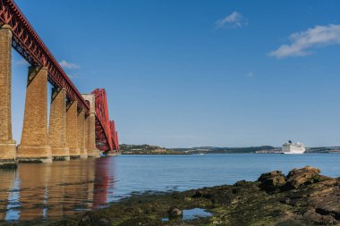 Güney Queensferry, Edinburgh, İskoçya, İngiltere - 12 Eylül 2023: Forth Köprüsü 'nün görüntüsü ve bekleyen bir yolcu gemisi
