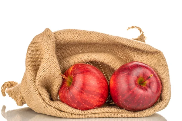 Red apple and green apple in basket with burlap background texture