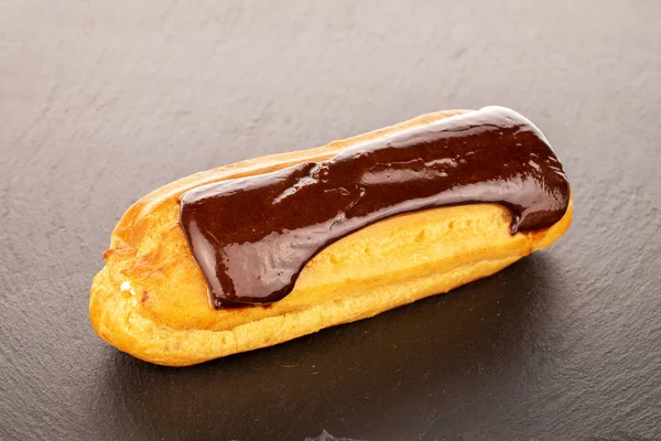 stock image One sweet eclair on a slate stone, macro.