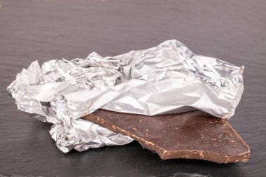 Bir çubuk siyah çikolata kayrak taşı üzerinde, makro.