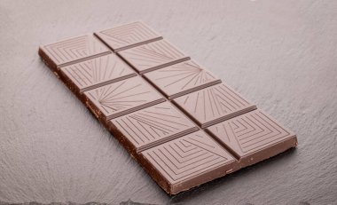 Bir çubuk siyah çikolata kayrak taşı üzerinde, makro.