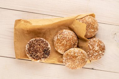 Tahta masa, makro ve üst manzara üzerinde kağıt torbalı birkaç tatlı zencefilli kurabiye..