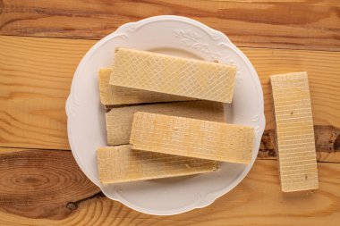 Tahta masa üzerinde beyaz seramik tabağı olan çikolatalı gofretler, yakın plan, üst manzara..