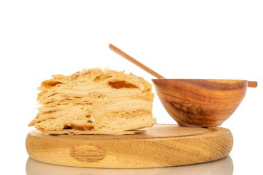 Tahta tepside bir parça kremalı pasta, beyaz arka planda izole edilmiş, ahşap bir fincan, makro..