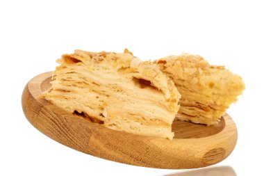 Tahta tepside iki parça kremalı pasta, makro, beyaz arka planda izole edilmiş..