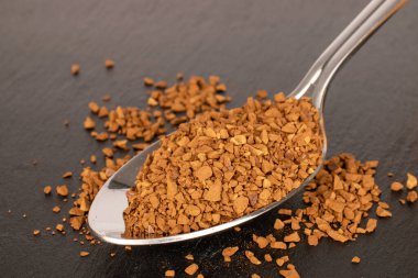 Kayrak taşı üzerinde metal kaşık olan hazır kahve, makro..