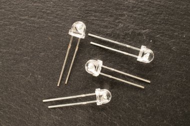 Four LEDs on slate stone, macro, top view.