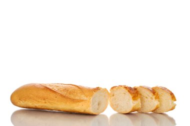 One fresh fragrant baguette sliced, macro, isolated on white background.