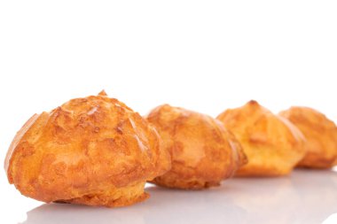 Several fresh fragrant chouquettes, on a white background.