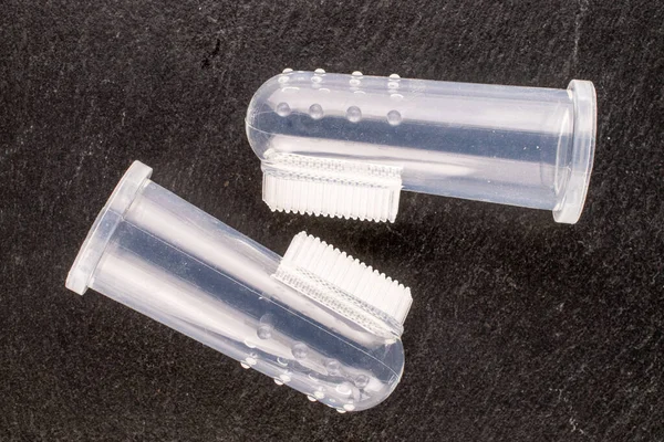 Two dog toothbrushes, macro, on slate stone, top view.