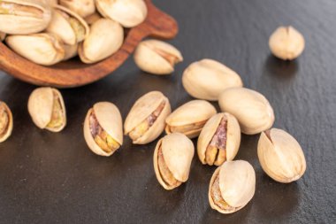 Tahta bir taşın üzerinde kabuksuz şam fıstığı, yakın plan..