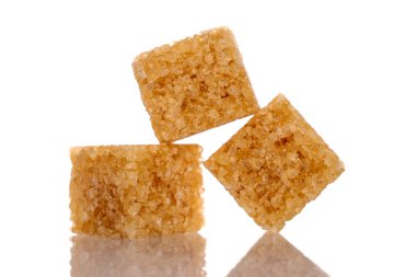 Three cubes of brown sugar, close-up, isolated on white.