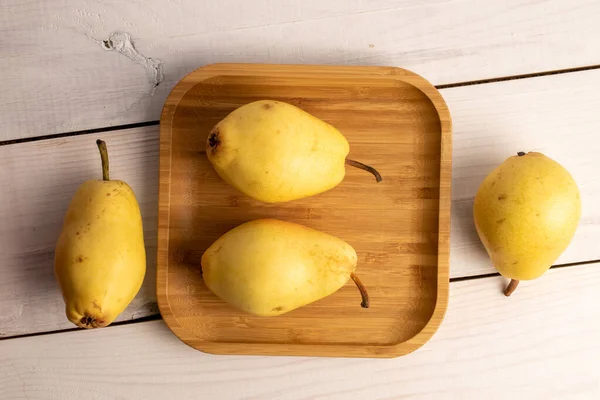 Several Ripe Yellow Pears Bamboo Plate Close White Wooden Table — ストック写真