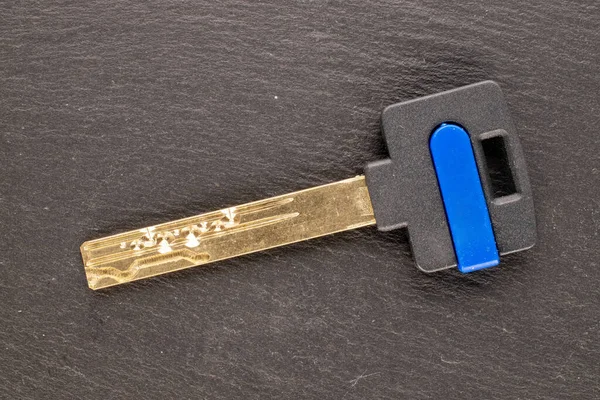 スレート石 マクロ トップビュー上の1つの金属ドアロックキー — ストック写真