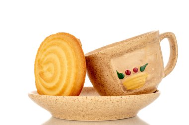 Beyaz arka planda izole edilmiş bir fincan ve makroyla seramik bir fincan üzerinde tatlı bir kurabiye..