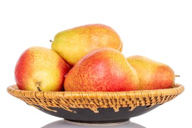 Seramik tabakta birkaç sarı-kırmızı armut, yakın plan, beyaz arka plan..