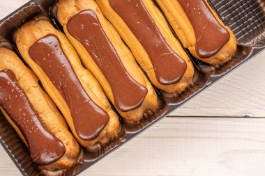 Tahta masanın üzerinde plastik tepsi olan birkaç çikolatalı ekler, yakın çekim, üst manzara..