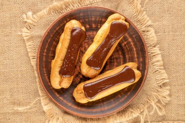 Üç çikolatalı pasta, kil plakalı jüt kumaş, yakın çekim, üst manzara..