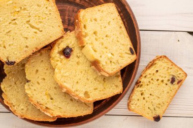 Dilimlenmiş ev yapımı kuru üzümlü kek, ahşap masa, makro, üst manzara..