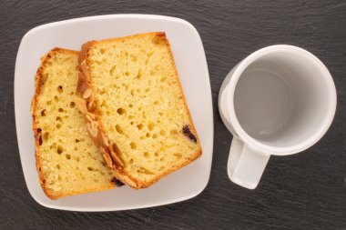 İki parça ev yapımı üzümlü kek, beyaz çay tabağı ve kayrak taşı, makro, üst manzara..