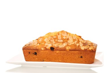 Beyaz porselen tabakta ev yapımı kuru üzümlü kek, makro, beyaz arka planda izole edilmiş..