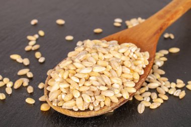 İnci ahşap bir kaşıkla kayrak taşı üzerinde homurdanıyor, makro.