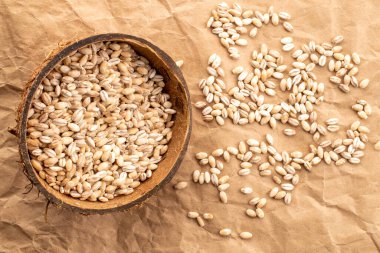 Hindistan cevizi kabuklu organik inci arpa. Kraft kağıdında, yakın plan, üst görüş..