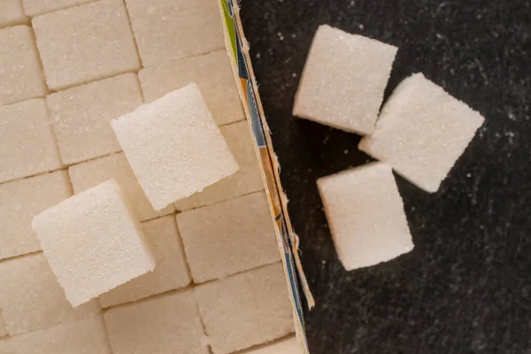 Verschillende Blokjes Witte Suiker Een Papieren Doos Leisteen Macro Bovenaanzicht — Stockfoto