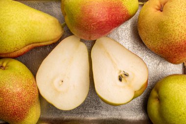 İki yarım ve birkaç tatlı armut bir metal tepside, yakın çekim, üst manzara..