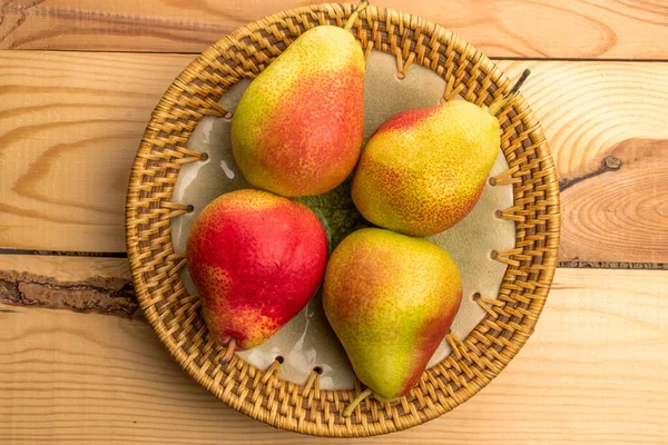 板の中の4つの甘いジューシーな梨 クローズアップ 木製のテーブル トップビュー — ストック写真