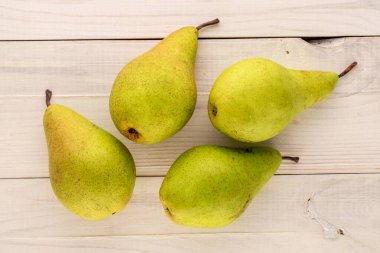 Tahta bir masada dört organik armut, makro, üst manzara..