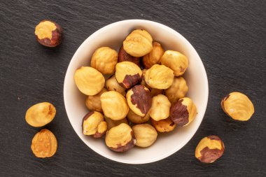 Kavrulmuş fındıklar ve beyaz seramik tabaklar kayrak taşı, makro, üst manzara..