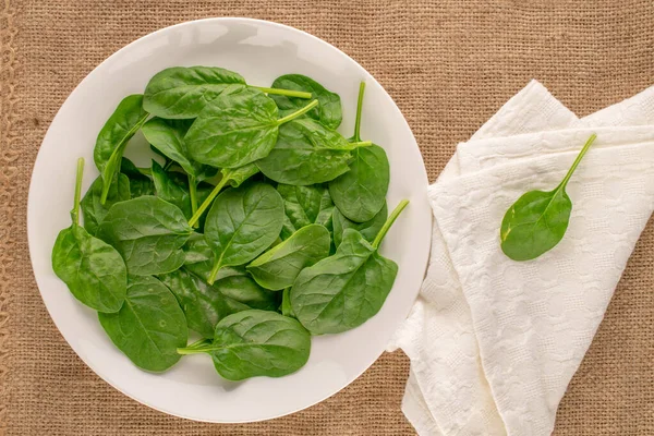 Fresh Green Spinach Leaves White Plate White Linen Napkin Jute — Stock Photo, Image