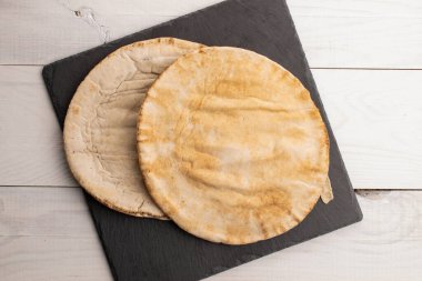 Tahtada taze pişmiş aromatik pide, yakın plan, boyanmış ahşap masa, üst görüş..