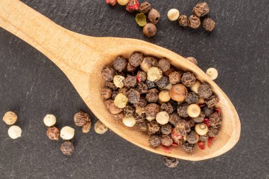 Dört biberli bezelye, ahşap kaşık, makro, kayrak taş, üst manzara..